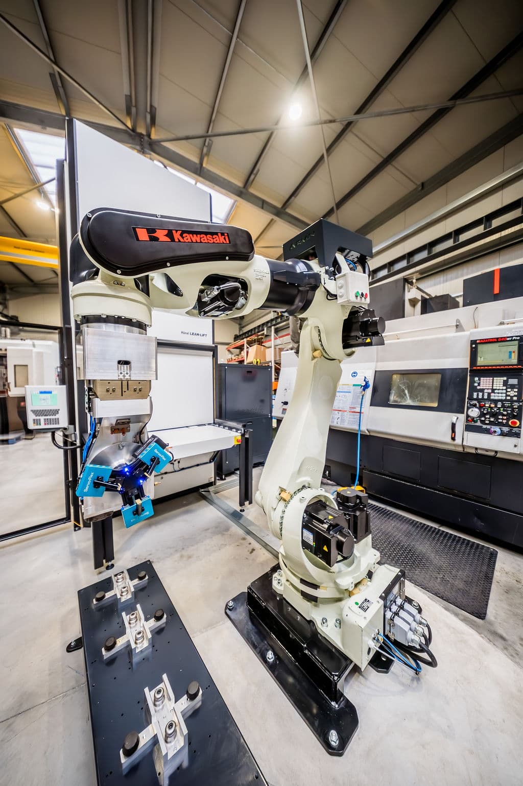 A Kawasaki robot fitted with a Servo-Flex gripper in a production cell